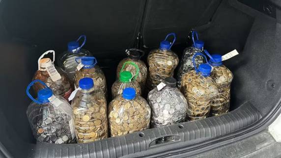 Comerciante Priscila Raupp chamou funcionários para ajudar na contagem. Comprador havia levado 13 galões de água cheios de dinheiro à revenda de carros em São José, na Grande Florianópolis.