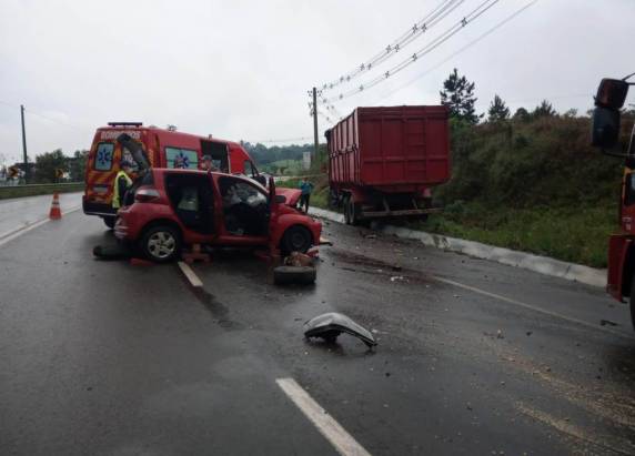 Vítima foi socorrida com fratura exposta em uma das pernas após colisão entre carro e caminhão.