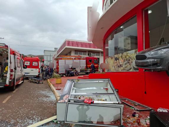 O carro entrou pela porta da frente do estabelecimento, atravessou o local e quebrou uma das vidraças, ficando com a parte dianteira suspensa para fora da parede.
