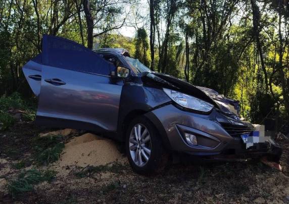 Caminhão carregado de ração tombou sobre um carro no km 61 da RSC-472; trânsito segue em sistema pare e siga enquanto equipes trabalham no local.