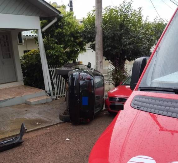 Veículo desceu desgovernado de ré, bateu no meio-fio e capotou; criança foi retirada pelo pai sem ferimentos.